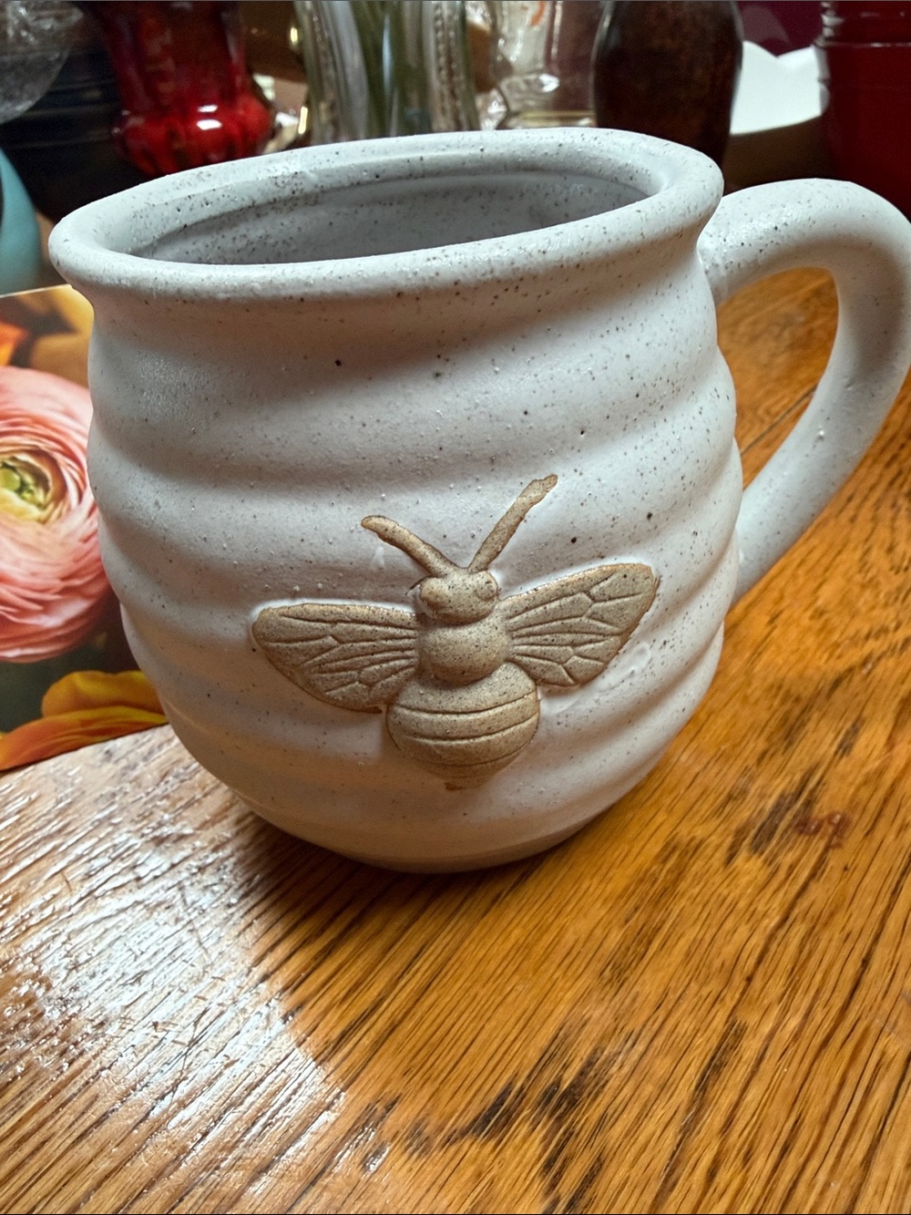 Dennis East pottery cup with 3D bee on front. Cream and tan.